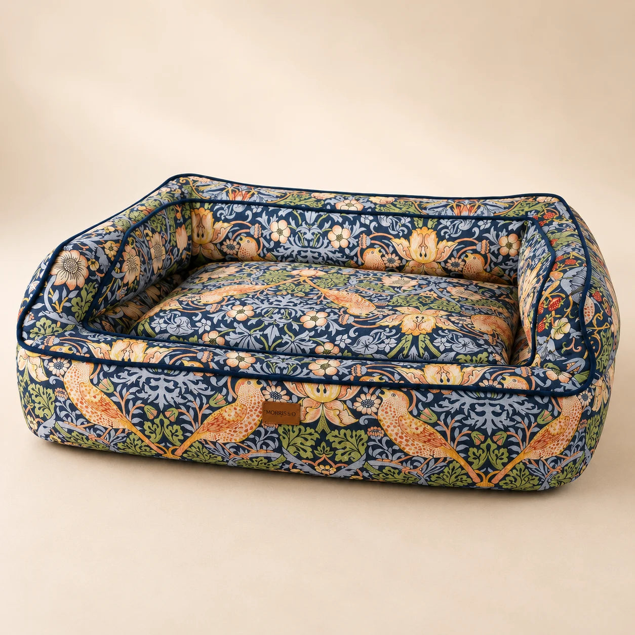 Morris and Co Strawberry Thief navy pet sofa showing its patterned cushion and raised sides