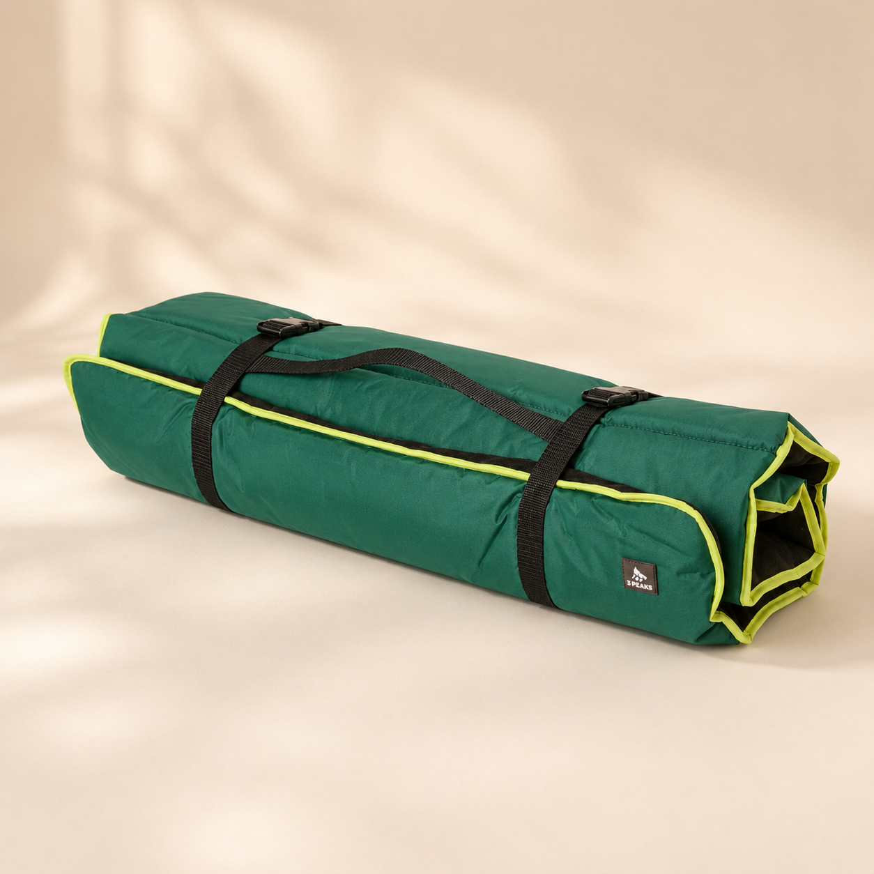 3 Peaks Roll Up Travel Dog Mat rolled for storage, showing green outer fabric, lime trim, black straps and carry handle