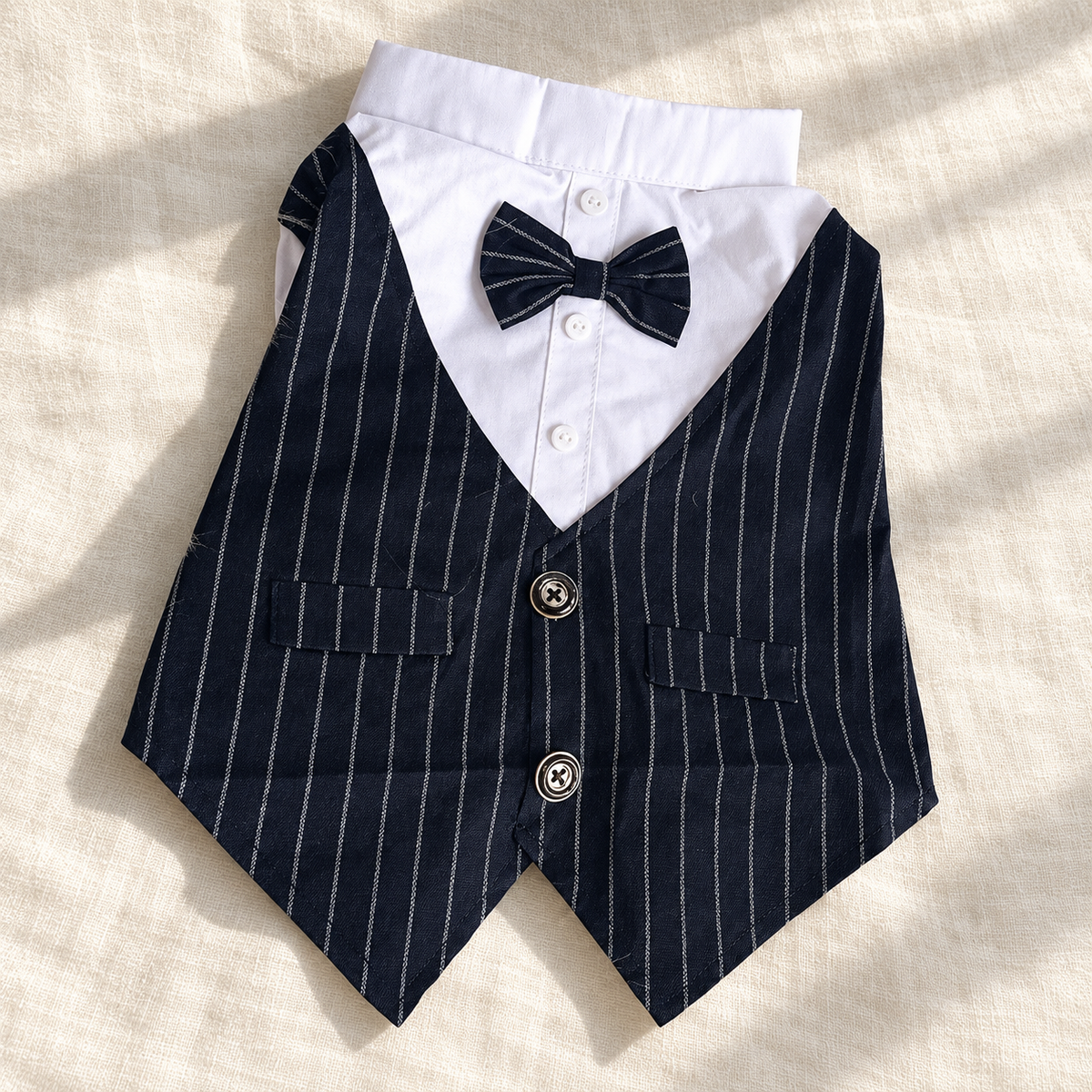 Two-button navy pinstripe dog waistcoat and white shirt laid flat on ivory linen